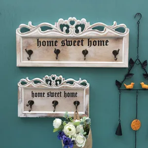 Detailaufnahme der hölzernen Wandhaken im Vintage-Stil mit dekorativem Home Sweet Home Schriftzug