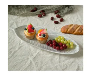 Detailed shot of a silver leaf-shaped serving tray with cupcakes and fresh fruit