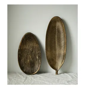 Detailed macro view of two golden leaf-shaped wooden trays with rich textures and finish.