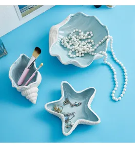 Vista dall'alto di vassoi per gioielli in ceramica a forma di conchiglia e stella marina