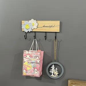 Decorative wooden wall coat rack detail with floral design and hooks for hanging