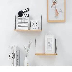 Set of minimalist wall-mounted wooden shelves with black hanging ropes in a lifestyle scene