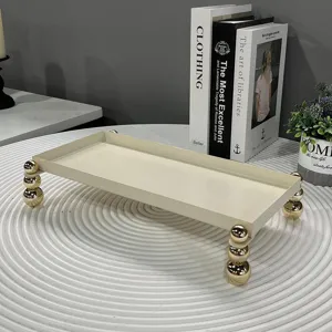 Elegantes cremefarbenes Eisen-Tablett mit dekorativen goldenen Kugelfüßen für die Aufbewahrung