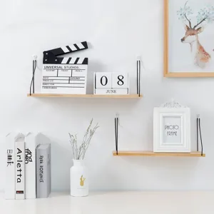 Minimalist wall-mounted wooden floating shelves with black metal hangers for home decor