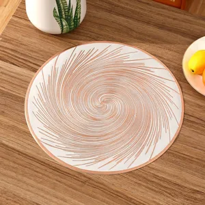 Elegant circular PVC placemat with a rose gold spiral swirl design on a wooden table.