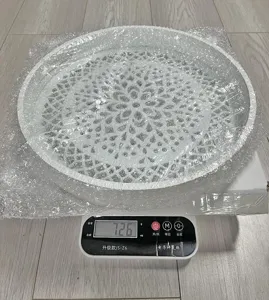 Detail view of the decorative wooden tray on a digital scale, showing its hollow pattern.