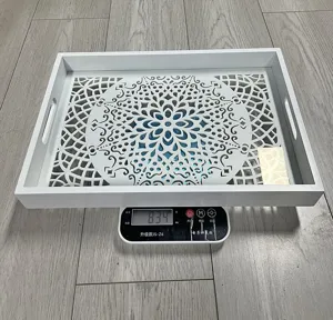 White wooden serving tray with cutout floral pattern, decorative tabletop organizer.