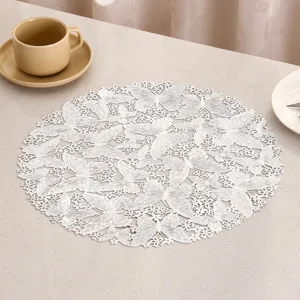 Close-up of circular white PVC placemat with elegant butterfly lace pattern for dining table