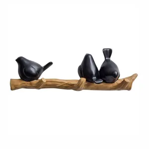 Modern Nordic style black bird wall hooks mounted on a branch base for home decoration.