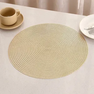 Close-up of golden PVC placemat featuring intricate hollow-out woven pattern for tables