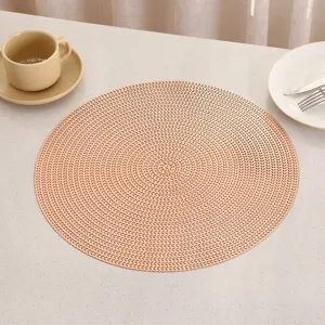 Close-up detail of elegant round PVC placemat showing its intricate woven gold texture