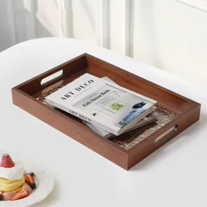 Wooden serving tray detail showing hollow pattern bottom and side handles in a cozy home setup.