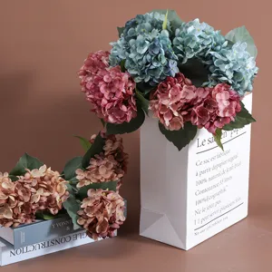 Detail van levensechte kunstmatige hortensia's in elegante papieren zak decoratie