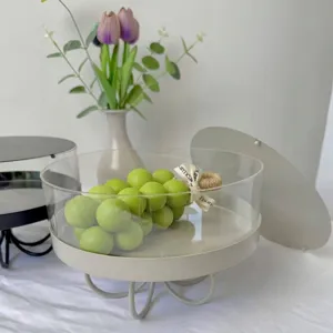 Vista lateral de un soporte para postres redondo de acrílico con base beige y uvas verdes