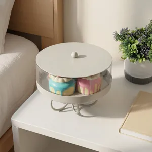 Elegant white acrylic dessert display stand with lid on a nightstand holding cakes
