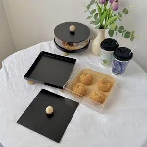 Detail of minimalist acrylic dessert box with matte black lid and wooden handle