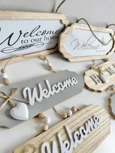 Close-up detail view of assorted rustic wooden welcome signs with decorative beads and jute rope