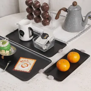Minimalistisches Set aus schwarzen matten Serviertabletts für Desserts in gemütlicher Atmosphäre