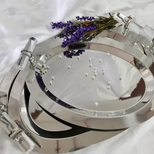 Detailed view of oval stainless steel tray with mirror finish and handles
