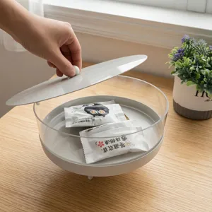 Close-up view of a modern acrylic dessert display stand with a gray metal lid being lifted