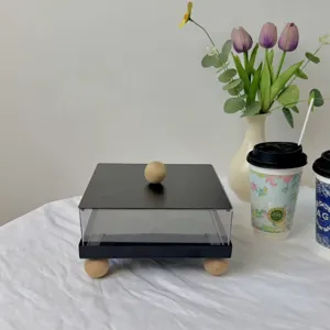 Modern square black and clear acrylic dessert display box featuring a round wooden handle