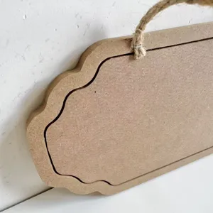 Close-up of a vintage wooden hanging plaque with jute rope and decorative wavy edges.