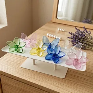 Detailed view of colorful glass flower and butterfly ornaments on a minimalist stand