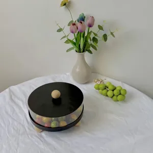 Vista detallada de una bandeja de fruta redonda minimalista con tapa negra