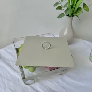 Primer plano detallado de una caja cuadrada para postres con tapa y asa de anillo