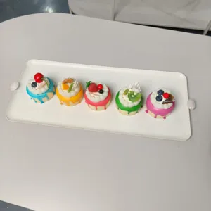 Minimalistisches weißes rechteckiges Metall-Desserttablett mit Griffen und bunten Cupcakes