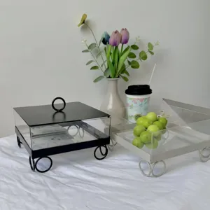 Primer plano de cajas cuadradas para postres en negro y beige con tapas transparentes.