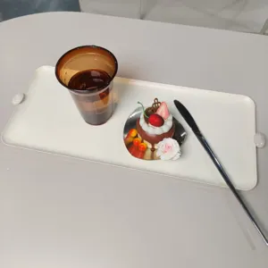 Makroansicht der cremefarbenen rechteckigen Dessertplatte aus Eisen mit Griffen