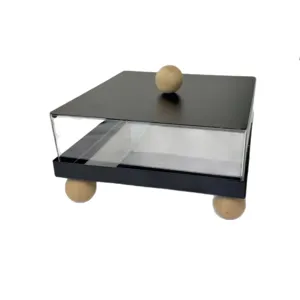 Modern acrylic dessert display stand with black lid and wooden ball feet on white background.