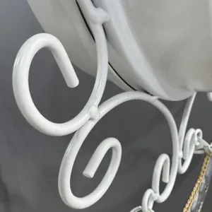 Close-up of white wrought iron scroll detail on a vintage double-sided wall clock