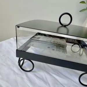 Vista macro detallada de una caja de postres cuadrada de metal negro con tapa clara