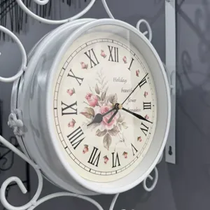 Close-up of vintage iron double-sided wall clock with floral and Roman numeral dial.