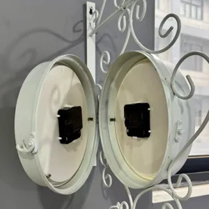 Detail view showing dual internal quartz movements of a white double-sided wall clock.