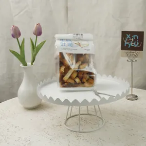 Detailed view of white metal cake stand with elegant scalloped edge and wire base