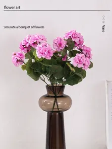 Détail d'un bouquet d'hortensias artificiels roses dans un vase en verre marron