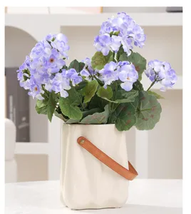 Vue détaillée d'hortensias artificiels violets réalistes dans un vase en céramique.
