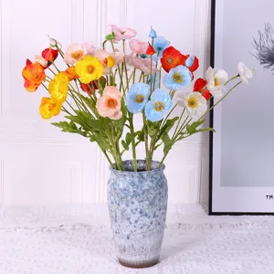 Hermosas flores de amapola artificiales multicolores en un jarrón de cerámica rústico