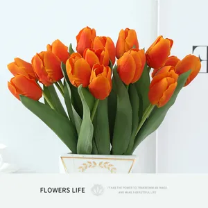 Detailed view of vibrant orange moisturizing artificial tulips in a marble gold vase