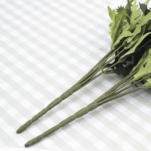 Close-up macro detail of realistic artificial daisy stems with green leaf attachments