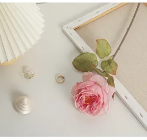 Detailed view of a pink burnt-edge artificial rose used as a lifestyle decor prop.