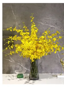 Detailansicht hellgelber Seiden-Oncidium-Orchideen in einer transparenten Glasvase