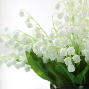 Macrodetail van kunstmatig lelietje-van-dalen met witte klokvormige bloemen
