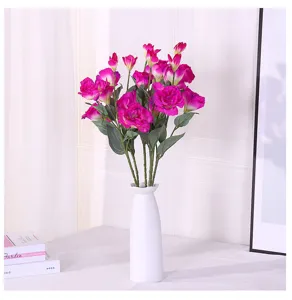 Detail showing vibrant pink artificial Lisianthus flowers in a sleek white ceramic vase.