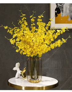 Lebhafte gelbe Oncidium-Seidenblumen in einer modernen goldgerahmten Vase als Dekoration