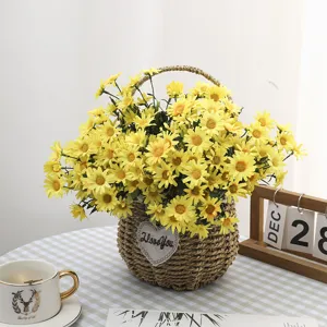 Detailed view of yellow artificial daisies set in a woven heart basket for home decor