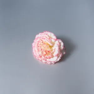 Makroansicht eines einzelnen künstlichen rosa-weißen Nelken-Blütenkopfs Dekors.